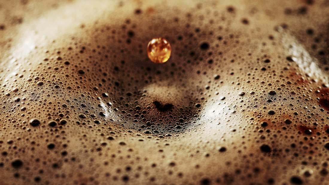 Close up of coffee with one drop causing a ripple effect. 